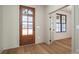 This bright entryway showcases the beautiful wooden front door, adjacent room with a dark trimmed window, and wood floors at 229 Golf Course Rd, Maiden, NC 28650