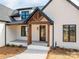 A welcoming front porch with dark wood pillars supporting a wooden roof and a beautiful glass-paneled door at 229 Golf Course Rd, Maiden, NC 28650