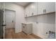 Well-lit laundry room with white cabinets, grey drawers and vinyl floor at 229 Golf Course Rd, Maiden, NC 28650