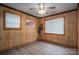 The bedroom features wood-paneled walls, a ceiling fan, and a view of the landscape from windows at 231 Cheek Rd, Clover, SC 29710