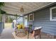 Inviting covered porch features comfortable seating and a view of the wooded landscape at 231 Cheek Rd, Clover, SC 29710