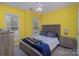 Bright bedroom with yellow walls, wood furniture, a ceiling fan, and natural light from the window at 2512 Holly Oak Ln, Gastonia, NC 28056