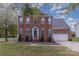 Traditional two-story brick home with a well-manicured lawn and trimmed landscaping at 2512 Holly Oak Ln, Gastonia, NC 28056