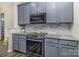 Modern kitchen with gray cabinets, granite counters, and stainless steel appliances at 2512 Holly Oak Ln, Gastonia, NC 28056