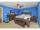 Bedroom with a blue accent wall, ceiling fan, and wooden furniture at 2512 Holly Oak Ln, Gastonia, NC 28056