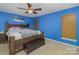 Bedroom with a blue accent wall, ceiling fan, and wooden furniture at 2512 Holly Oak Ln, Gastonia, NC 28056