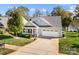 Charming light blue home with an inviting porch, mature landscaping, attached garage, and lake view at 25566 Seagull Dr, Lancaster, SC 29720