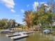 Picturesque waterfront view featuring a private boat dock with multiple boats, mature trees, and lake access at 25566 Seagull Dr, Lancaster, SC 29720