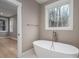 Bathroom featuring a white freestanding tub, modern fixtures, and a view of the forest outside the window at 6630 Vesuvius Furnace Rd # 1, Denver, NC 28037