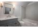 Modern bathroom featuring a grey vanity, tiled walls, and a shower and tub combination at 6630 Vesuvius Furnace Rd # 1, Denver, NC 28037