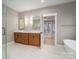 Bathroom featuring double sinks, a modern design, and a doorway leading to the bedroom and balcony at 6630 Vesuvius Furnace Rd # 1, Denver, NC 28037