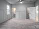 Neutral bedroom with carpet, paneling, and two doorways to the adjacent bathroom at 6630 Vesuvius Furnace Rd # 1, Denver, NC 28037