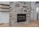 Close-up view of a stone fireplace with a black firebox and rustic wooden mantel at 6630 Vesuvius Furnace Rd # 1, Denver, NC 28037