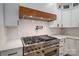 Close up of a professional-grade stainless steel gas range and wooden vent hood at 6630 Vesuvius Furnace Rd # 1, Denver, NC 28037