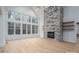 Bright living room featuring a stone fireplace, wooden floors, and a wall of large windows at 6630 Vesuvius Furnace Rd # 1, Denver, NC 28037