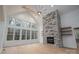 Bright living room featuring a stone fireplace, wooden floors, and a wall of large windows at 6630 Vesuvius Furnace Rd # 1, Denver, NC 28037