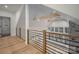 Bright loft area with hardwood floors, wooden beams, high ceilings, modern railings, and stone fireplace at 6630 Vesuvius Furnace Rd # 1, Denver, NC 28037