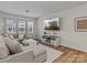 Living area featuring a sectional sofa, mounted TV, and hardwood floors at 118 Berkeley Ave # D, Mooresville, NC 28117