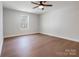 This bedroom features hardwood floors, a modern ceiling fan, and a window offering natural light at 119 E Ohio Ave, Bessemer City, NC 28016