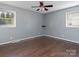 Bedroom with a ceiling fan, laminate flooring, and natural light from two windows at 105 Victoria Dr, Statesville, NC 28625