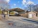 Practical carport providing shelter for vehicles, alongside a storage building, enhancing outdoor convenience at 105 Victoria Dr, Statesville, NC 28625