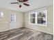 Neutral-toned living room with new flooring, ceiling fan, and a large window for ample natural light at 105 Victoria Dr, Statesville, NC 28625