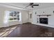 Bright living room featuring hardwood floors, white brick fireplace, and large window at 105 Victoria Dr, Statesville, NC 28625