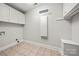 Laundry room with tiled floors, hanging cabinets, and wall mounted shelving at 2545 Rea Rd, Charlotte, NC 28226