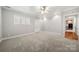 Carpeted living room with windows, white trim, and entry door to the kitchen at 2545 Rea Rd, Charlotte, NC 28226