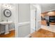 Hallway view of powder room with pedestal sink, with a peek into the kitchen beyond at 2545 Rea Rd, Charlotte, NC 28226