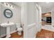 Traditional powder room with pedestal sink, round decorative mirror, and hardwood floors at 2545 Rea Rd, Charlotte, NC 28226