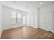 Light-filled bedroom with hardwood floors, neutral walls, white trim, and doors to closet and private balcony at 4018 Capital Ridge Ct, Charlotte, NC 28205