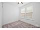 Light bedroom featuring neutral carpet, two large windows, and minimalist decor at 4018 Capital Ridge Ct, Charlotte, NC 28205