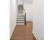 A wood staircase ascends next to hardwood floors and white walls, creating a welcoming entrance at 4018 Capital Ridge Ct, Charlotte, NC 28205