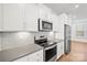 Close up of kitchen with stainless steel appliances, white cabinets, and gray subway tile backsplash at 4018 Capital Ridge Ct, Charlotte, NC 28205