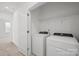 Bright laundry room with new washer and dryer, wire shelf, and natural light from the window at 4018 Capital Ridge Ct, Charlotte, NC 28205