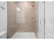 An attractive tiled shower with a glass door, shower head, and convenient handle at 4018 Capital Ridge Ct, Charlotte, NC 28205
