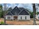 Beautiful exterior of home features stone accents, beige siding, black shutters and a front porch at 227 Heartland Dr, Rock Hill, SC 29732
