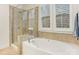 Bathroom with shower and bathtub, and window with shutters at 2624 Woodlands Creek Dr, Monroe, NC 28110