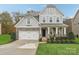 Two-story house with gray siding, stone accents, and a landscaped lawn at 2624 Woodlands Creek Dr, Monroe, NC 28110