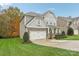 Two-story house with gray siding, stone accents, and a landscaped lawn at 2624 Woodlands Creek Dr, Monroe, NC 28110