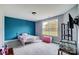 A modern bedroom with a striking blue accent wall and a large window with backyard views at 3018 Corinth Church Rd, Monroe, NC 28112