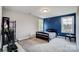 Bedroom featuring blue accent wall, carpet floors, two windows, and plenty of natural light at 3018 Corinth Church Rd, Monroe, NC 28112