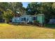 Green mobile home with landscaped yard and carport at 3401 Stony Brook Cir, Newton, NC 28658