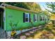 Green mobile home with stone accents and landscaping at 3401 Stony Brook Cir, Newton, NC 28658