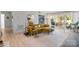 Bright living room with hardwood floors, large windows, and stylish mustard yellow couch at 7062 Quail Hill Rd, Charlotte, NC 28210