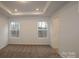 Main bedroom with tray ceiling, carpet, and two windows at 3540 Nimbell Rd, Monroe, NC 28110