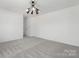 Spacious bedroom with neutral carpeting and modern light fixture at 7415 Linda Lake Dr, Charlotte, NC 28215