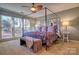 Comfortable bedroom with a four-poster bed, ceiling fan, and large windows for natural light at 94 Heritage Dr, Lake Wylie, SC 29710