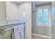 Modern tiled shower with glass enclosure complemented by open shelving and window at 94 Heritage Dr, Lake Wylie, SC 29710